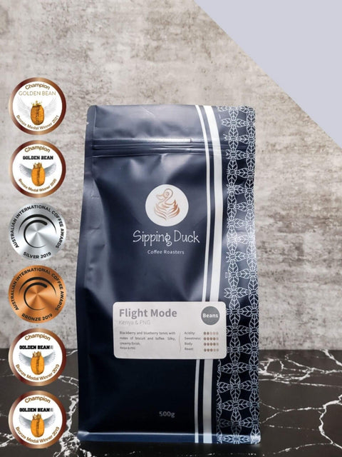 Sipping Duck Coffee Roasters Flight Mode blend with Golden Bean and AICA  award medals.