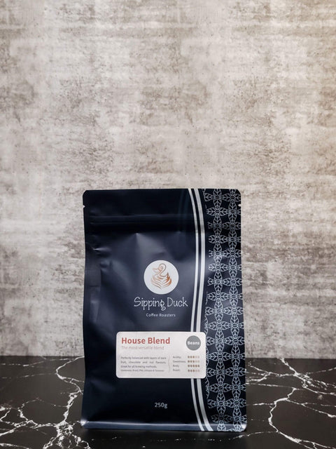 Sipping Duck Specialty Coffee Roasters House Blend 250g bag, blue with unique pattern.