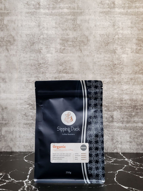 Sipping Duck Coffee Roasters Organic blend in blue 250g bag with unique pattern and label with blend description.