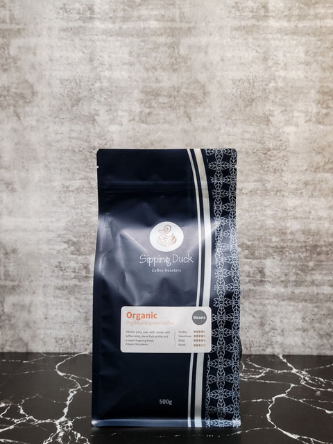 Sipping Duck Coffee Roasters Organic blend in blue 500g bag with unique pattern and label with blend description.
