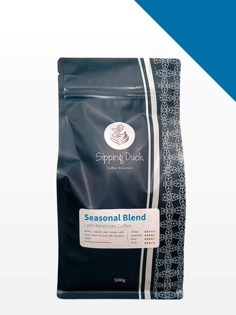 Sipping Duck Seasonal Blend, latin American, in blue bag with unique pattern and label with blend description. Blue right corner.