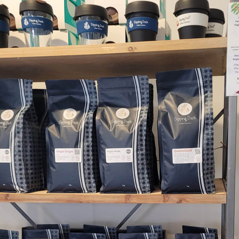 Sipping Duck coffee bags and Keep Cups on shelves.