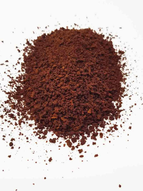 Specialty instant coffee granules on white surface.